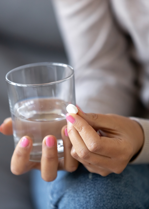 Patient holding a glass of water and a tablet